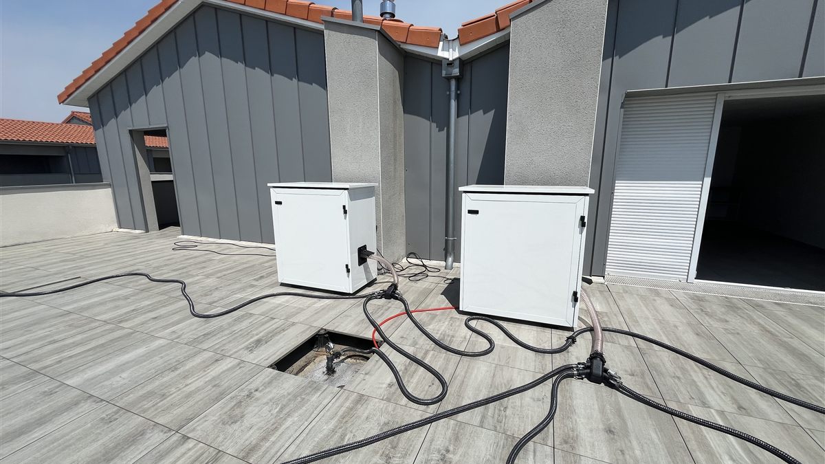 Deux caissons d'assèchement Audit'Eau posés sur une terrasse carrelée, raccordés au complexe par des flexibles.
