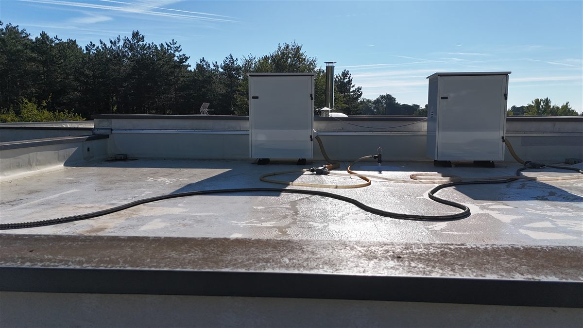 Deux caissons d'assèchement Audit'Eau en poste sur une toiture-terrasse béton, raccordés par des flexibles.